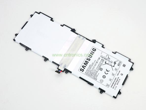 取出電池前要把周圍的帶狀電纜先拔出來，這個比較容易。Galaxy Note 10.1的電池容量為7000mAh,3.7V，預(yù)計續(xù)航時間8小時左右，重約136克，占據(jù)了整體重量的23%。不過為了減少機(jī)身厚度，電池做得很薄。